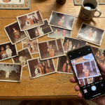 Old Halloween photos spread across a table with a smartphone capturing a family costume photo